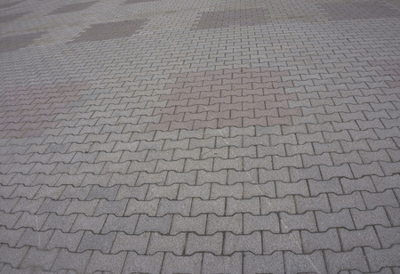 Texture of gray and yellow patterned paving tiles on the ground of street, perspective view. Cement...