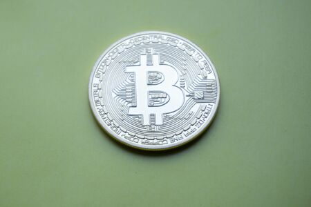 Golden Bitcoins (digital virtual money) on a green background.の写真素材