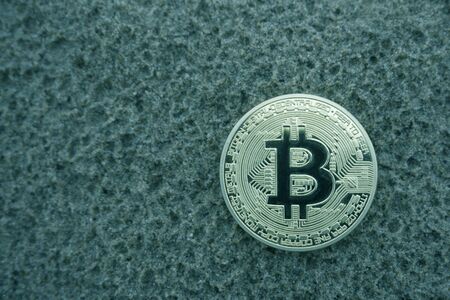 Golden bitcoin coin in the sandの写真素材