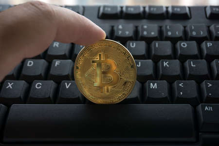 golden bitcoin on keyboardの写真素材