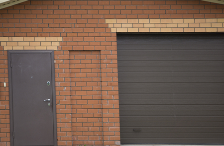 house and garage on the left side, which has a concrete yard, lighting under the roofの写真素材