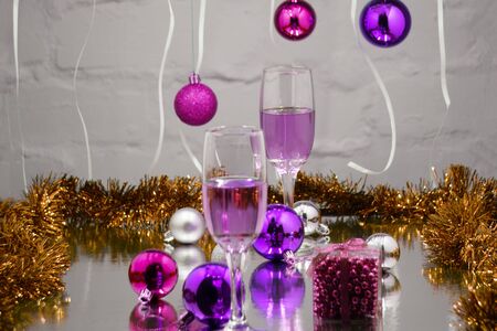 Champagne in glasses and blurred lights on red backgroundの写真素材