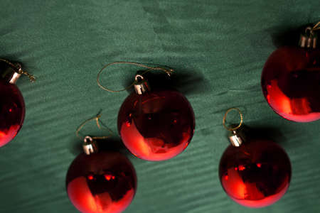 Red christmas balls on green paper background. studio shot