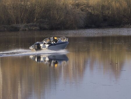 boy fishing . an old man sitting in a boat with a fishing rod. view from the back. floats