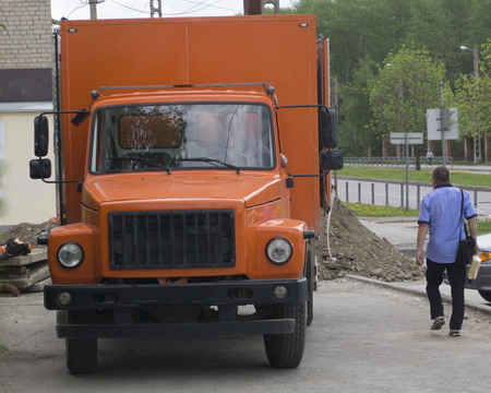 Red, orange truck and cleaning machine at the city street.forefront of a machine brush city. urban service car. Municipal car forの写真素材