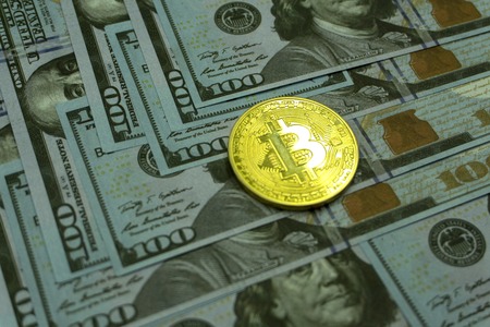 Coins bitcoin on a background of 100 American dollars close-up ,の写真素材
