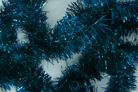 Closed up Christmas decoration tinsel. A golden shiny tinsel popped up on red backgroundの写真素材