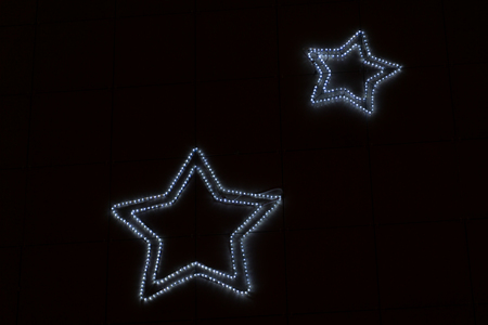 Photo of golden star with light bulbs on red velvet curtain on stage .