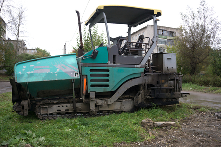 industrial pavement truck laying fresh asphalt on construction site