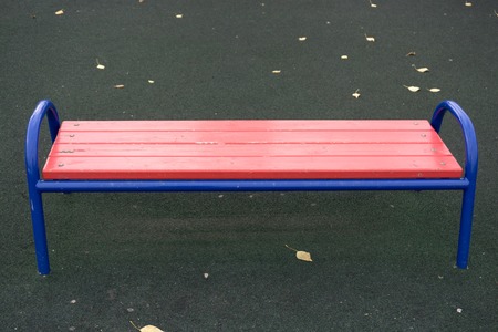 Vividly red empty bench tree white wood