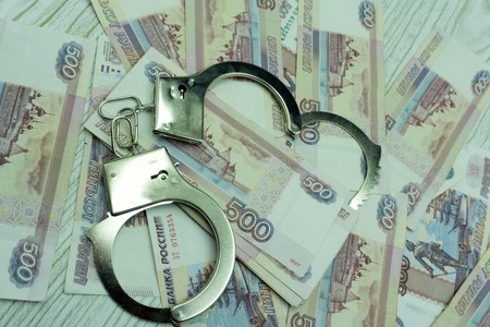 Handcuffs on money shackles shiny sign silverの写真素材
