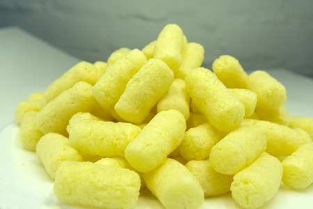 Sweet crunchy corn sticks or snacks isolated on white backgroundの写真素材