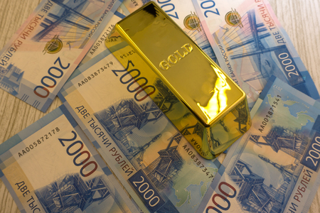 Closeup of golden bullion on hundred dollars banknotes backgroundの写真素材