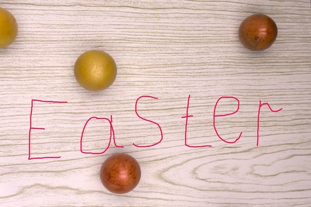 Easter eggs on a wooden table next to the flowers of lilac. Easter theme. Easter background