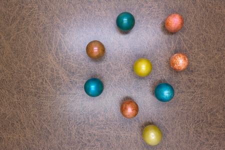Colorful decorative and plain easter eggs arranged in random circular pattern on green grass. Close up flat view from aboveの写真素材