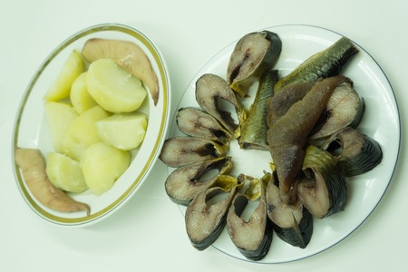 Herring fish with potatoes and onion, rye bread on the table with fork. top view