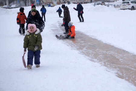 Russia Berezniki 20 February 2018: children and adults slide down the icy hell on the city square in winter. Winter landscapeのeditorial素材