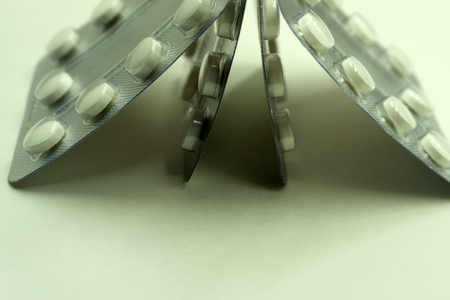 Tablet pills in blister pack on white background. Chewable tablet pills for treatment parasite in human. Anthelmintic effective against threadworm or pinworm, whipworm, roundworm, hookworm, tapewormの写真素材