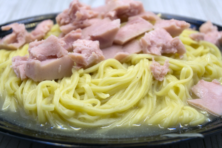 eating instant noodles with sauce and luncheon meat close upの写真素材