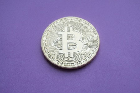 Golden Bitcoins (digital virtual money) on a purple background.の写真素材