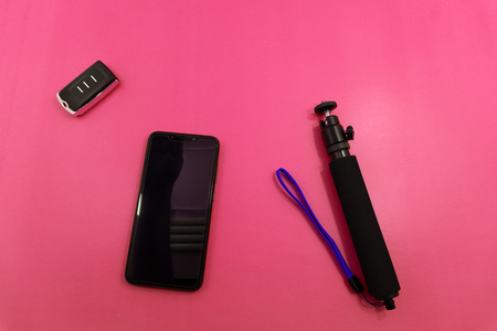 summer vacation concept stylish pink sunglasses phone on selfie stick headphones, and green palm leaves on pink background flat lay space for text time to travel .の写真素材