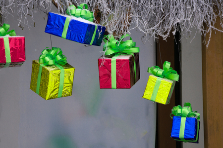 Red gift boxes hanging on a ribbon Old brown paper background .の写真素材