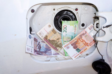 Money sticking out of automobile fuel closed tank conceptの写真素材