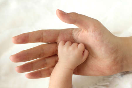 mother holding the baby's handの写真素材