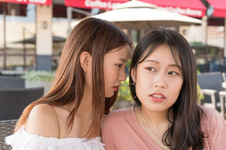 two girls are whispering