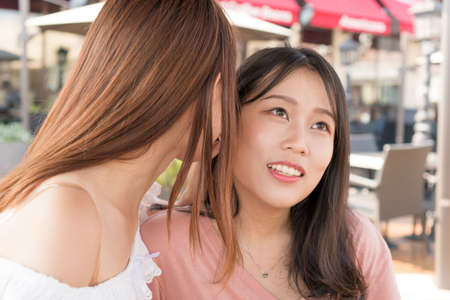 two girls are whispering