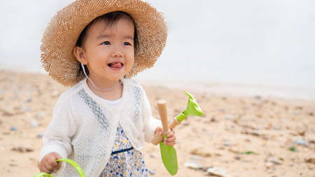 asian baby playing by the beachの写真素材