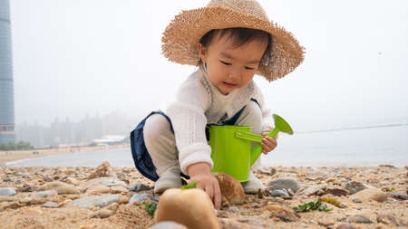 asian baby playing by the beachの写真素材