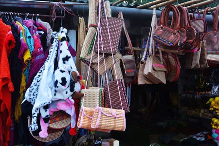 Close up of a shop displaying varieties of handicraft local goods like bags, shawls in Elephant falls of Shillong for sale, selective focusingの写真素材