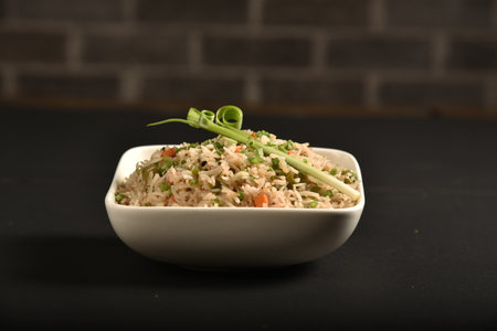 Fried rice is a dish of cooked rice that has been stir-fried in a wok or a frying pan and is usually mixed with other ingredients such as eggs, vegetables, seafood, or meatの写真素材
