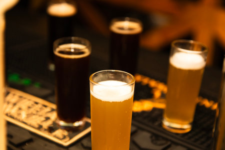 Glasses of beer on table in pub, shallow depth of field