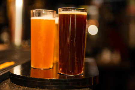 Two glasses of beer on a bar counter in a pub or restaurantの写真素材