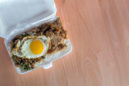 Rice topped with stir-fried pork and basil on foam boxの写真素材