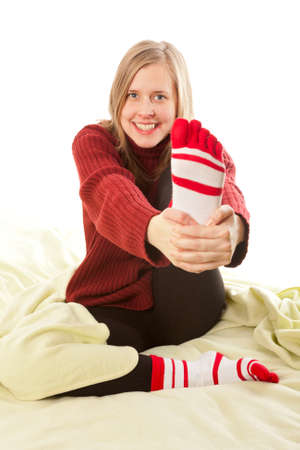 Beautiful young woman smiling and holding her foot の写真素材