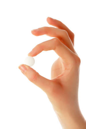 Beautiful female hand holding a white, round pill.の写真素材