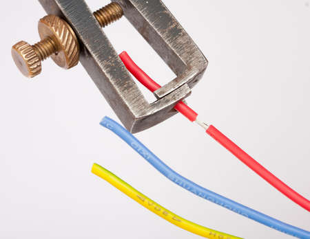 Stripping a red cable with a wire stripper plier の写真素材