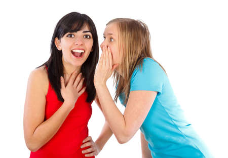 Young brumette whispering the news to her friend 