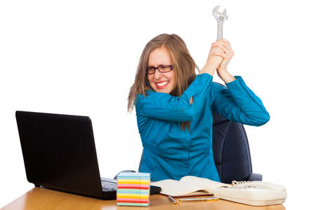 Young woman about to break her laptop at work の写真素材
