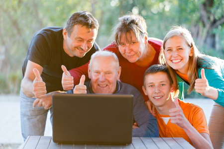 Happy family showing thumbs up for technology.