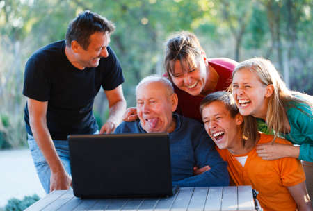 Family laughing together at the funny grandfather.の写真素材