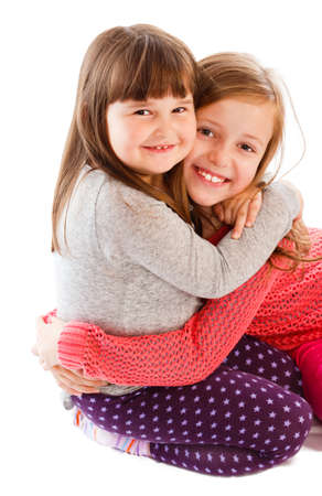 Adorable little sisters showing love to each other, hugging.の写真素材