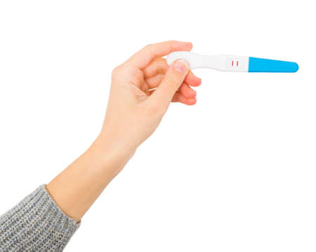 Female hand showing positive pregnancy test, expecting a baby.
