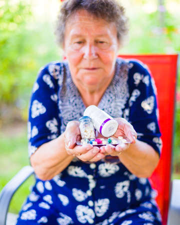 Close-up of a senior woman holding medicines outdoor.の写真素材