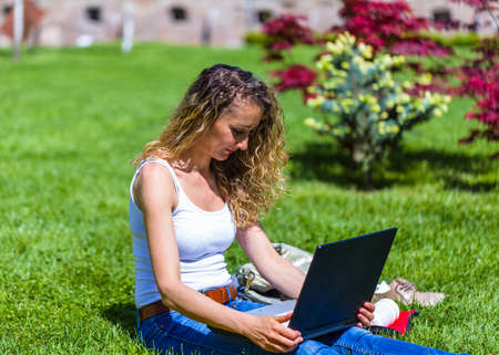 Pretty university student repeating outdoors materials before exam.の写真素材