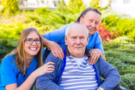 Portrait of elderly couple and doctor at elderly home park.の写真素材