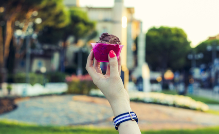 Sundae of chocolate ice cream in hand with the beautiful natural backgroundの写真素材